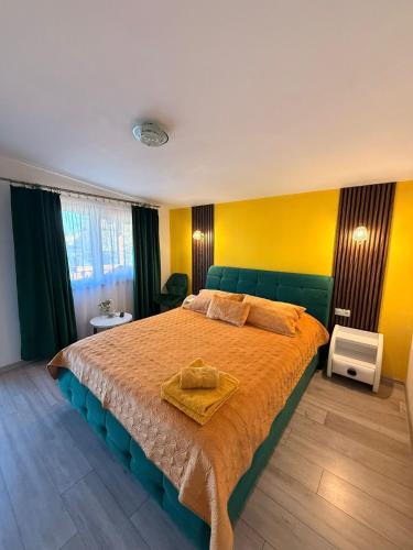 a bedroom with a large bed with a yellow wall at Sunset Expanse in Turda
