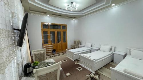 a room with two beds and a table in it at Daniel SAMARKAND in Samarkand