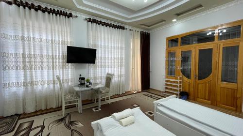a living room with a couch and a tv and a table at Daniel SAMARKAND in Samarkand