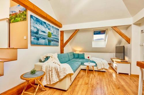 a living room with a blue couch and a tv at Villa Harmony in Český Krumlov