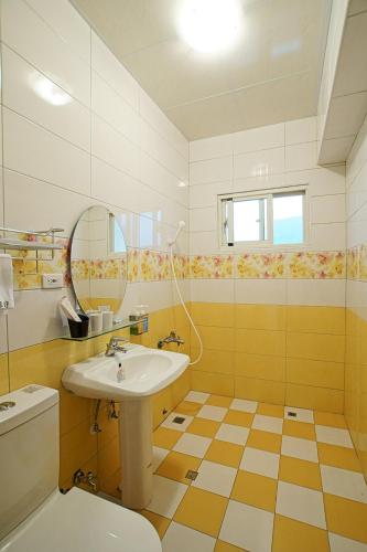 a bathroom with a sink and a mirror and a toilet at Du Du Hao B&B in Yongan