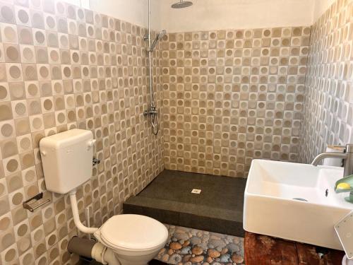 a bathroom with a toilet and a sink at EcoDream Lodge in Port Mathurin