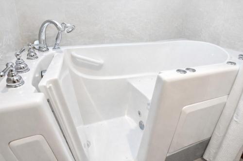 a bathroom with a white tub and a sink at Annabell Gardens in Lincoln