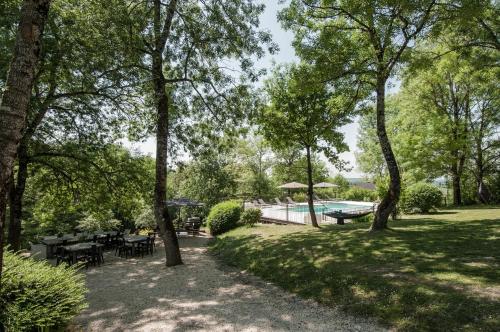 une cour avec une piscine, des tables et des arbres dans l'établissement Bassiviere Barn Chic, à Saint-Étienne-de-Villeréal