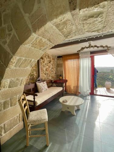 a living room with a couch and a chair at Ahiri traditional cottage in Galatás