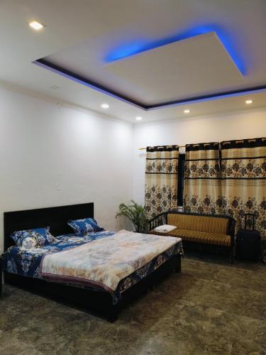 a bedroom with a bed and a blue light at Green Haven Farm & Events in Bhundsi