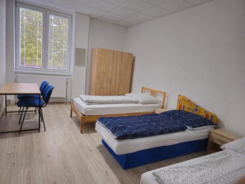 a room with two beds and a table and a desk at JOPEL ubytovanie v súkromí in Slovenské ďrmoty