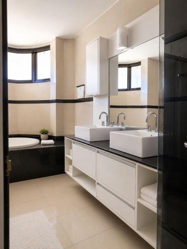 a bathroom with two sinks and a tub at Hotel Residence in Caruaru