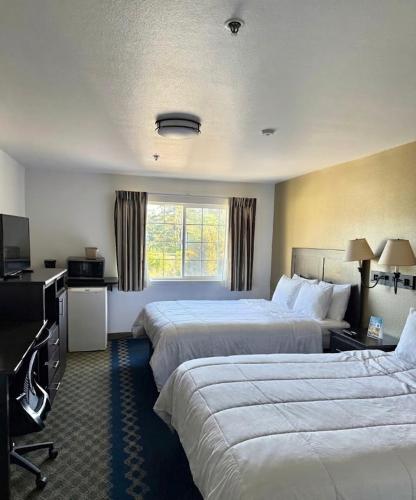 a hotel room with two beds and a television at Fidalgo Country Inn in Anacortes