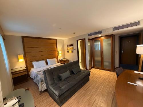 a hotel room with a bed and a couch at Hotel Wynd Ibirapuera 512A in São Paulo