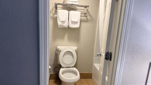 a small bathroom with a toilet and towels at Atlantic Crest Inn and Suites in Myrtle Beach