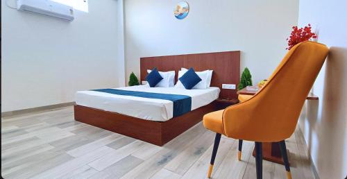 a bedroom with a bed and a chair in a room at Foreste Resort in Rāmnagar