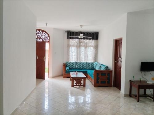 a living room with a blue couch and a table at D & N Homes- Villa 1 in Kalutara