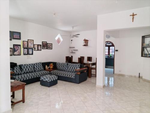a living room with a couch and a cross on the wall at D & N Homes- Villa 1 in Kalutara