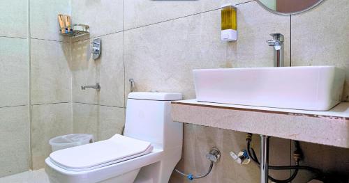a bathroom with a white sink and a toilet at Foreste Resort in Rāmnagar