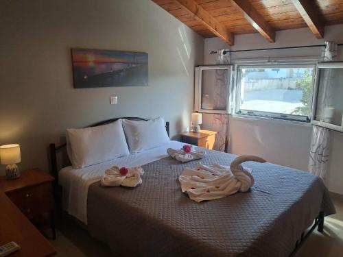 a bedroom with a bed with two swans on it at Aggelos's house in Nótos