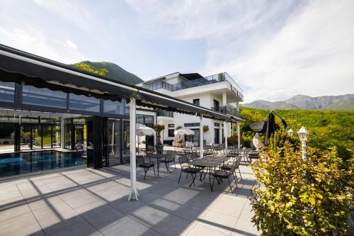 a building with a patio with tables and chairs at White House Radac Peja in Peje