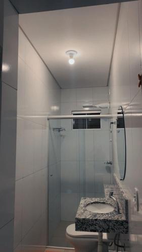 a bathroom with a glass shower with a sink at hOTEL CALIFORNIA in Barreiras