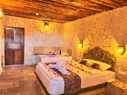 a bedroom with two beds and a stone wall at MMF cave house in Nevşehir