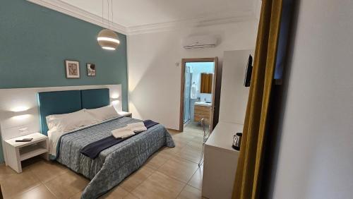 a bedroom with a bed with a blue headboard at Janva Guest House in Sciacca