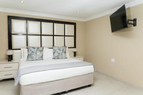 a bedroom with a bed and a flat screen tv at Kunjalo Lodge in Inadan