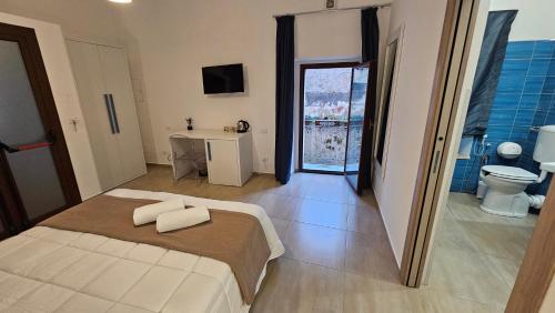 a bedroom with a bed and a bathroom with a toilet at Janva Guest House in Sciacca