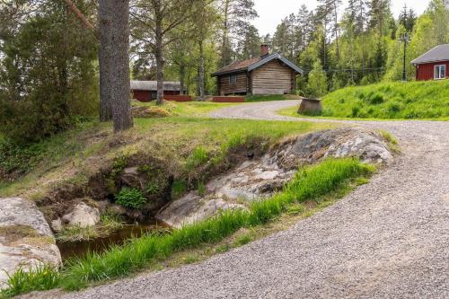 a gravel road leading to a cabin in a forest at Midsommar Stuga in Årjäng