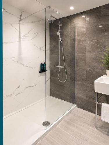 a shower with a glass door in a bathroom at The Regency Hotel in Solihull