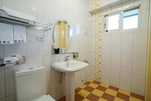 a bathroom with a sink and a toilet and a mirror at Du Du Hao B&B in Yongan