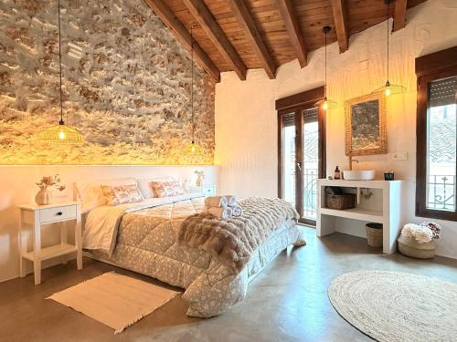 a bedroom with a bed and a stone wall at ruralhome sanroque in Altura