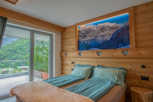 a bedroom with a bed and a large window at Dolomites Chalet Wolf in Molveno