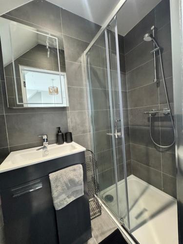 a bathroom with a sink and a glass shower at Ultra cozy in Brookmans Park