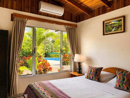 a bedroom with a bed and a large window at Hotel Villas Vilma in Fortuna