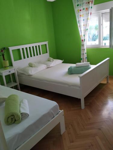 two beds in a room with green walls at toni in Makarska