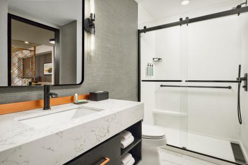 a bathroom with a sink and a shower at Apiary Hotel Belleview Station Denver in Denver