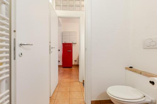 a bathroom with a toilet and a red refrigerator at Dimora Pia in Piacenza