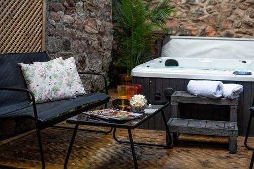 a patio with a tub and a chair and a table at Wonderland Berwick 5-bedrooms Pet-friendly cottage with the Hot tub in Tweedmouth