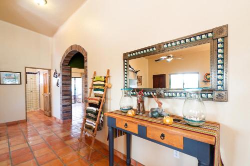 a living room with a mirror and a wooden table at Pool Oasis Close to the Beach and Pickleball in Las Palmas
