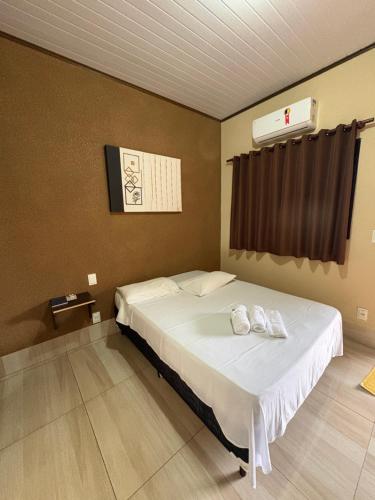 a bedroom with a bed with two towels on it at Pousada Os Galeguinhos in Santa Cruz do Rio Pardo