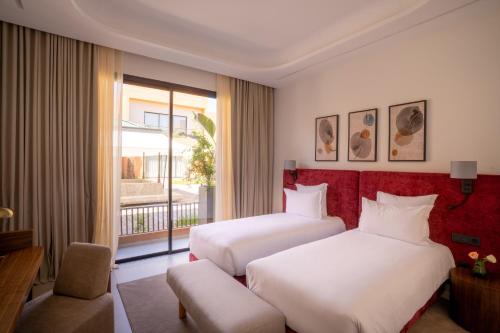 a hotel room with two beds and a window at TRIANON Résidence Hôteliere in Marrakesh