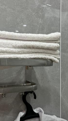 a group of towels on a rack in a bathroom at Эталон АПАРТ-ОТЕЛЬ Aqtobе in Aktobe