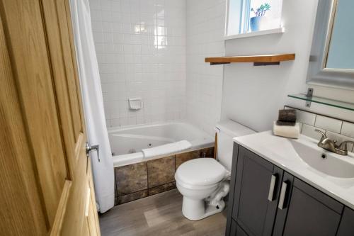a bathroom with a toilet and a tub and a sink at Rising Tide- Cabin In Ucluelet in Ucluelet