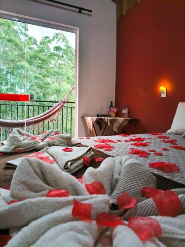 a room with a bed with towels on it at Pousada Vale do Horizonte in Monte Verde