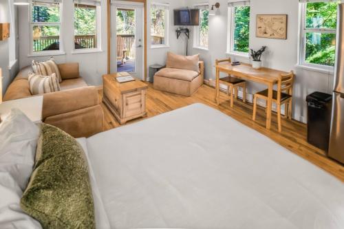 a living room with a bed and a table at Rising Tide- Cabin In Ucluelet in Ucluelet