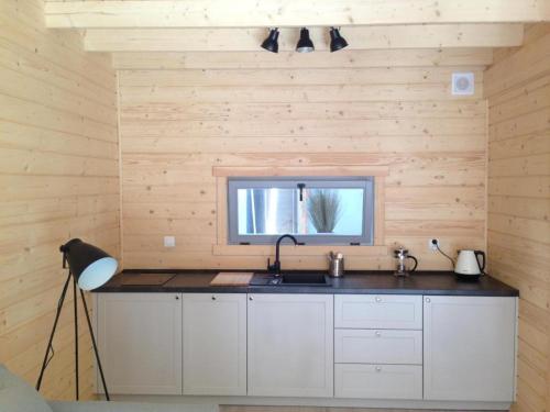 a kitchen with a sink and a window at Domki Między Sosnami in Pobierowo