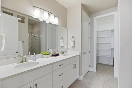 a white bathroom with two sinks and a large mirror at Royal Rock Adventures in Washington