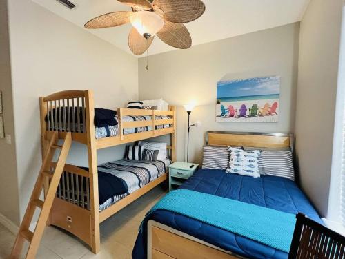 a bedroom with two bunk beds and a ceiling fan at Family Retreat with pool for 6 Pet Lovers 130 E Retama #3 in South Padre Island