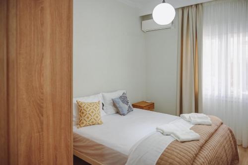 a bedroom with a white bed with pillows on it at Datidis Urban Nest in Komotini