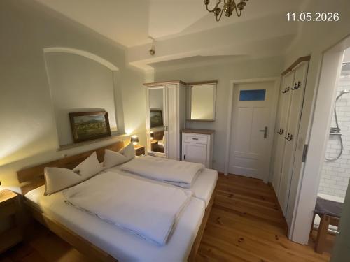 a bedroom with a large white bed with white pillows at Ferienwohnung "Altes Schloss Wilhelmsfeld" in Eselsberg