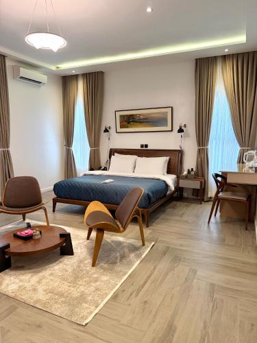 a bedroom with a bed and a table and chairs at ASFARO Apartments in Abuja